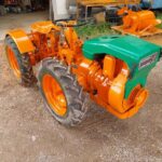 Tractor articulado Pasquali 910 con tracción a las cuatro ruedas, arado y cultivador.