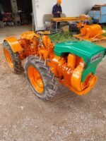 Tractor articulado Pasquali 910 con tracción a las cuatro ruedas, arado y cultivador.